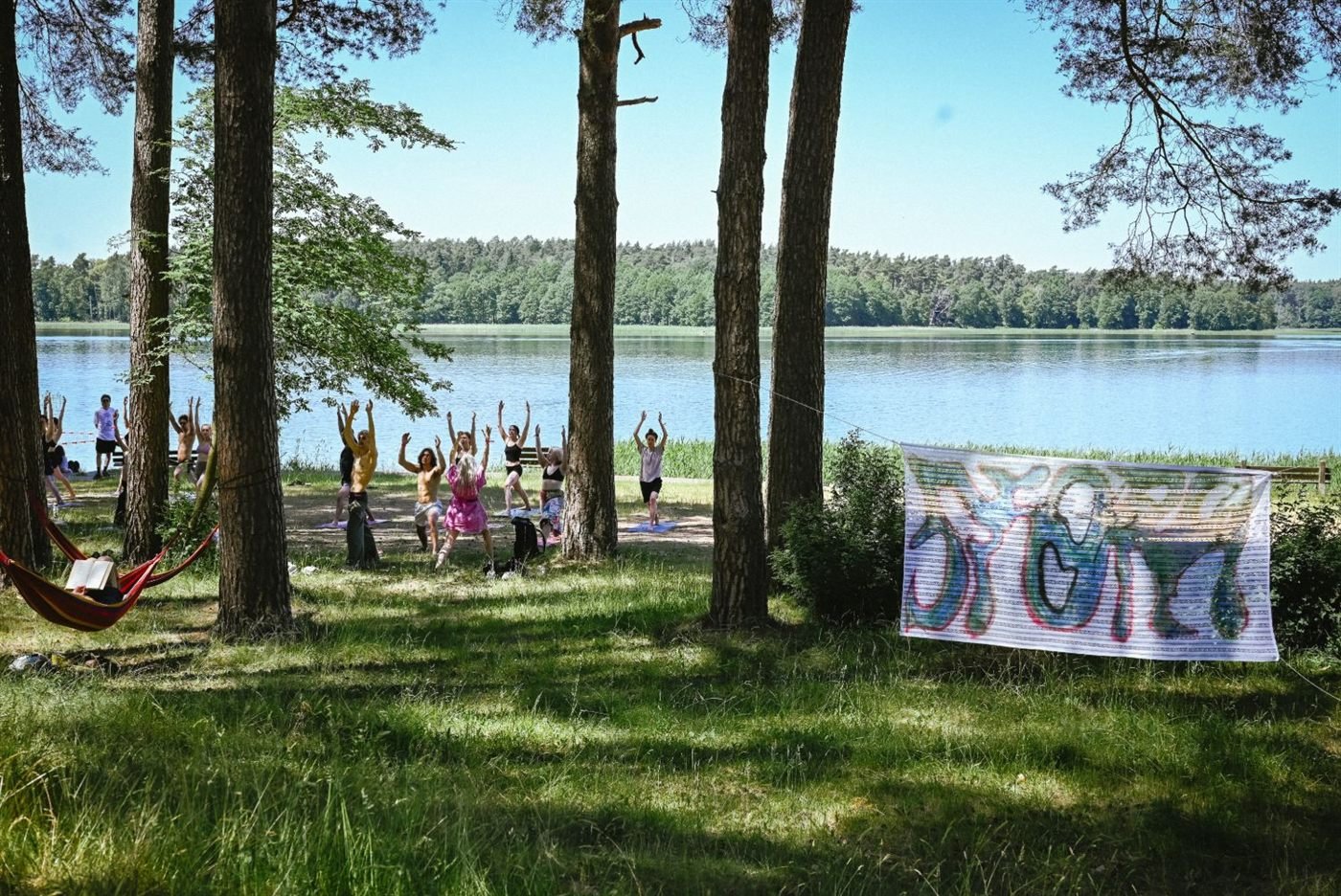 Joga na plaży nad jeziorem, między sosnami